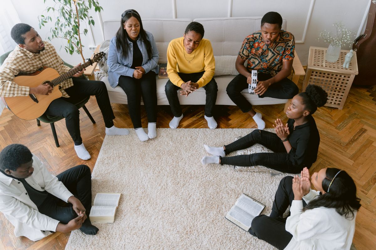 Young people sitting in a circle with Bibles and a guitar during a discipleship session
