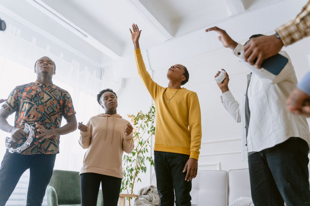 Young people singing and raising their hands in worship